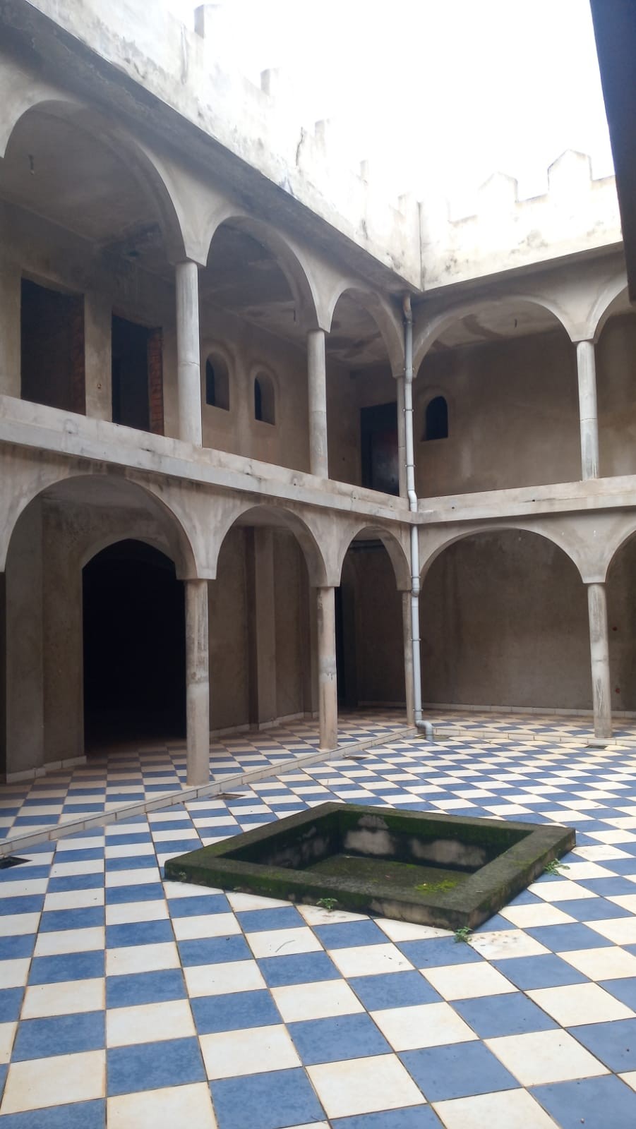 Relais Castle Moroccan β Two-story courtyard with arches, columns and blue/white checkered floor with central basin